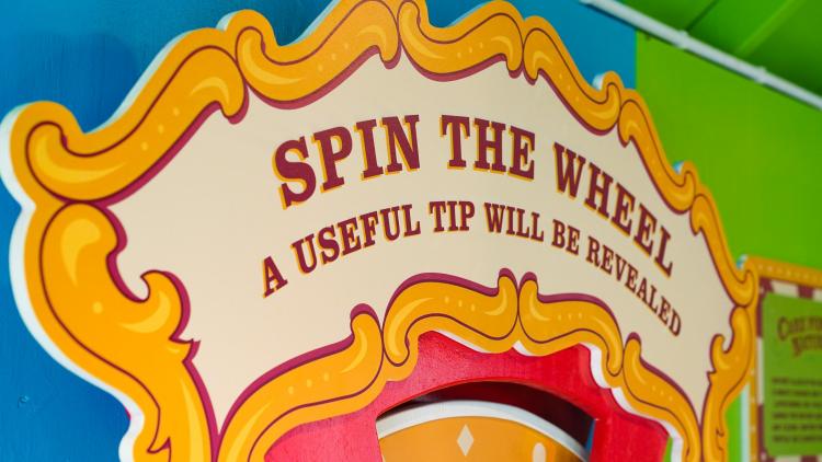 Sign from the Tunnel of Love exhibit which reads 'spin the wheel and a useful tip will be revealed'