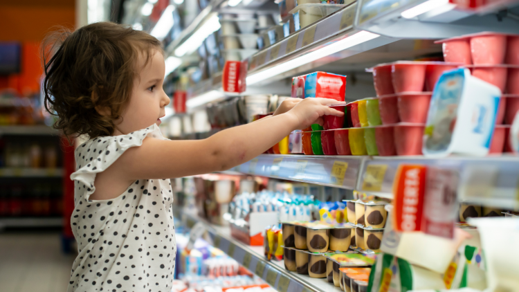 Child picking items from shelf in supermarket