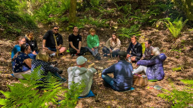 Group of adults sitting together in a circle in nature