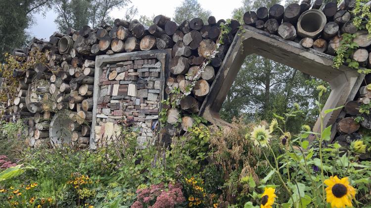 Wall made of logs and bricks designed to be a home for bugs and insects