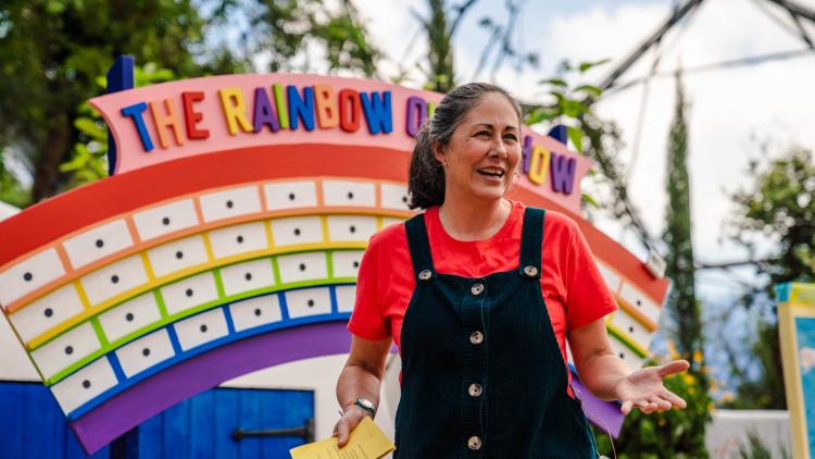 Lady standing in front of rainbow quiz sign