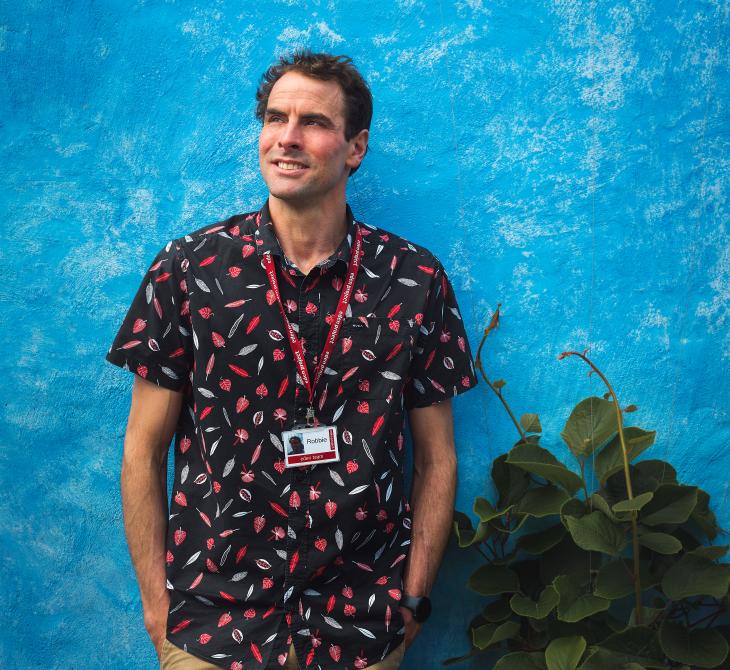 Eden employee Robbie Kirkman standing in front of a blue wall in the Mediterranean Biome