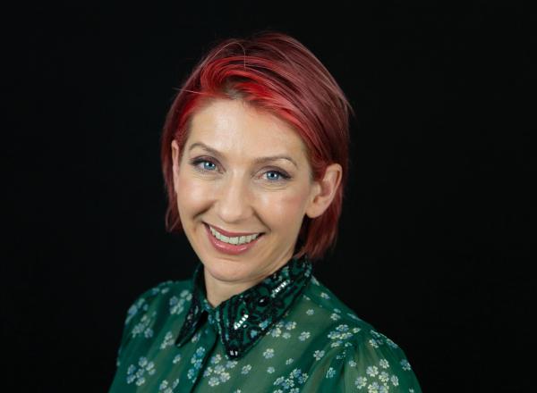 Image of Erica Neve, Eden Trustee smiling at the camera with a black background