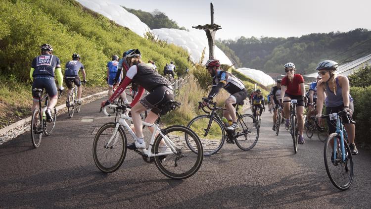 Cyclists on a path in front of the Biomes at the Eden Project 