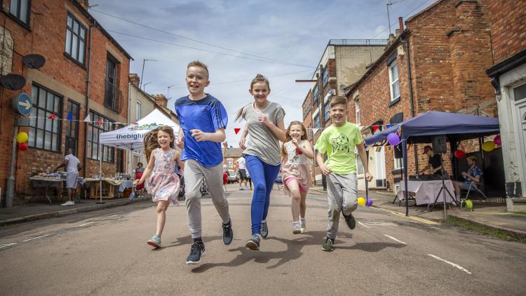 Children running down an open street