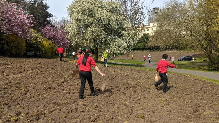 School children sowing seed in Princes Park, Toxteth, Liverpool.