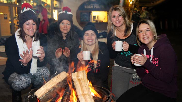 Group of ladies drinking hot chocolate by a fire pit