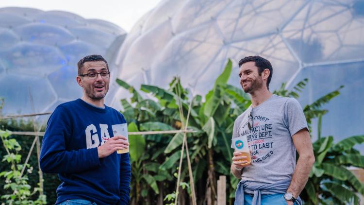 Men enjoying a drink in front of Eden's Biomes