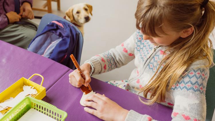 Girl and dog doing craft activity