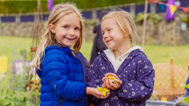 Two girls holding felt bees