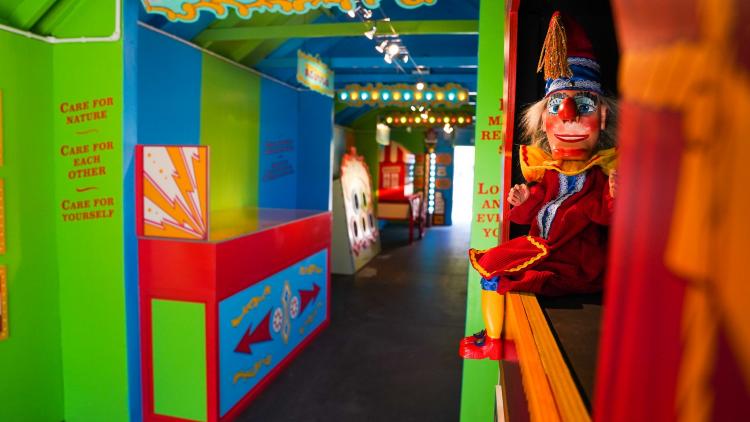 Inside of the Tunnel of Love exhibit shows bright colours and a Punch and Judy style puppet