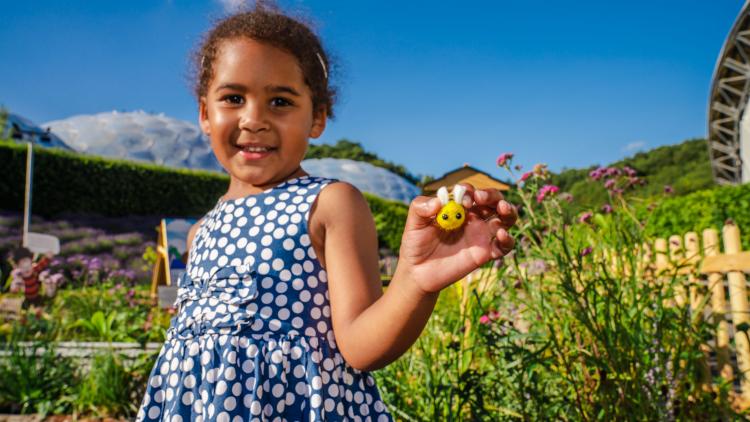 Girl holding felt bee playing pollination game