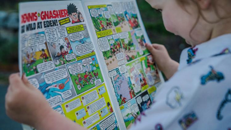 Child reading Eden themed Beano comic