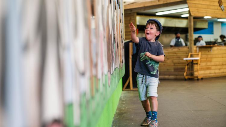 Boy playing game by hitting giant corks to stop cow farts and burps