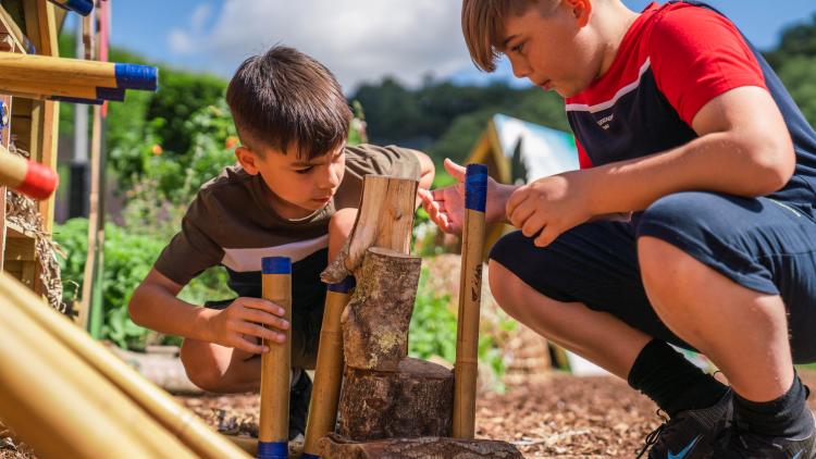 Boys playing game gathering bamboo for a bug hotel