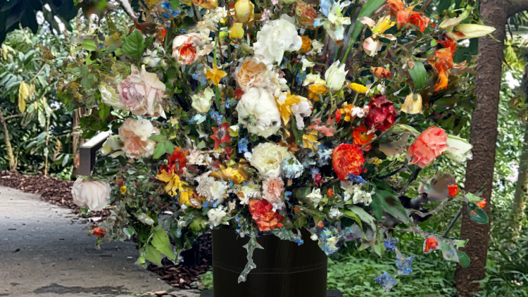 An AR art work of a bouquet of flowers on a plinth in one of the Biomes.