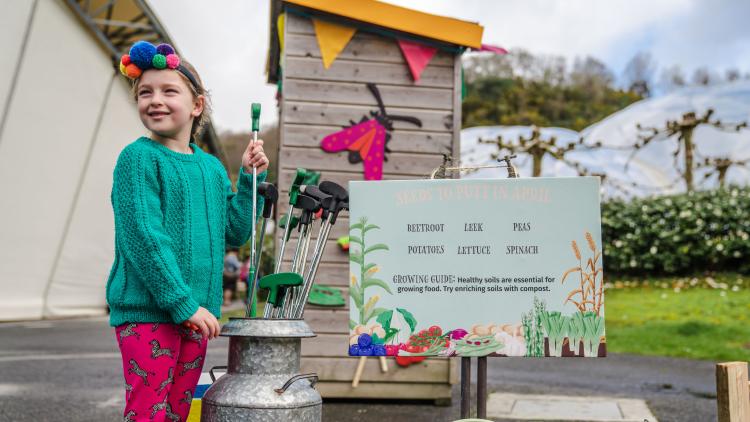 Girl collecting a golf club from a milk churn at the Eden Project