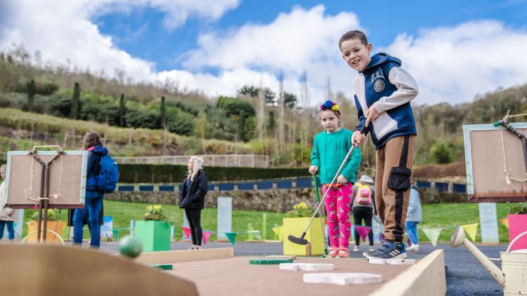 Boy playing mini golf