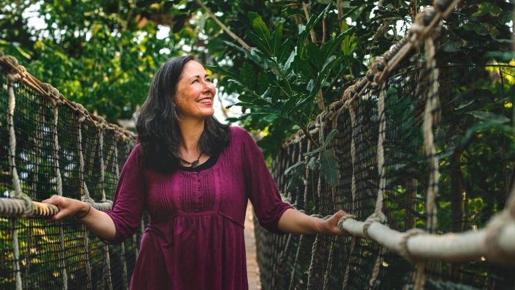 Woman crossing the wobbly rope bridge in Eden Project's Rainforest Biome