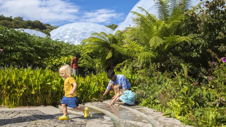 Young family playing in the outdoor gardens at the Eden Project