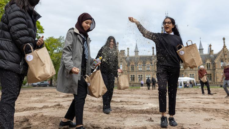 Teenage school girls throwing seeds