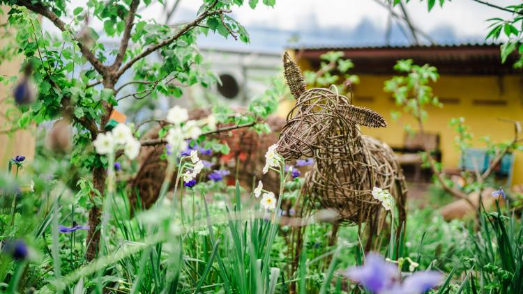 Willow deer surrounded by spring flowers