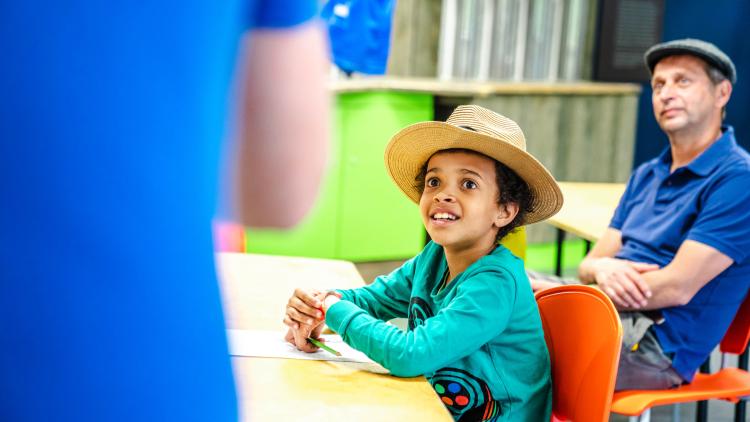 Boy in a straw hat doing a writing workshop