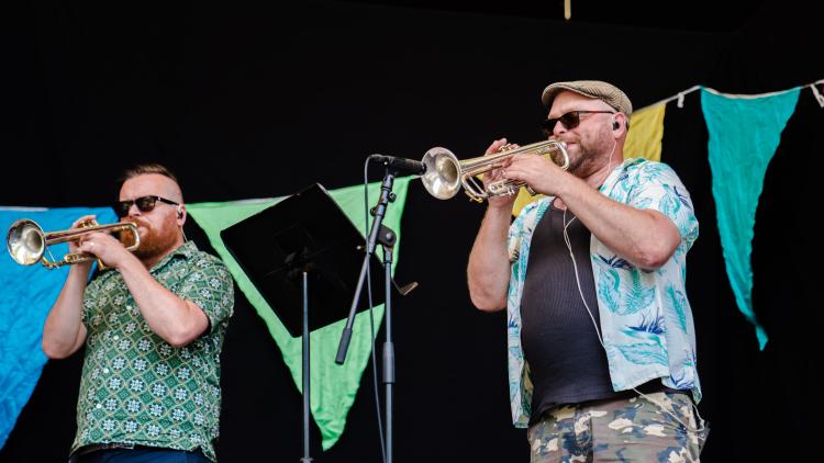 Trumpet players with giant bunting behind them