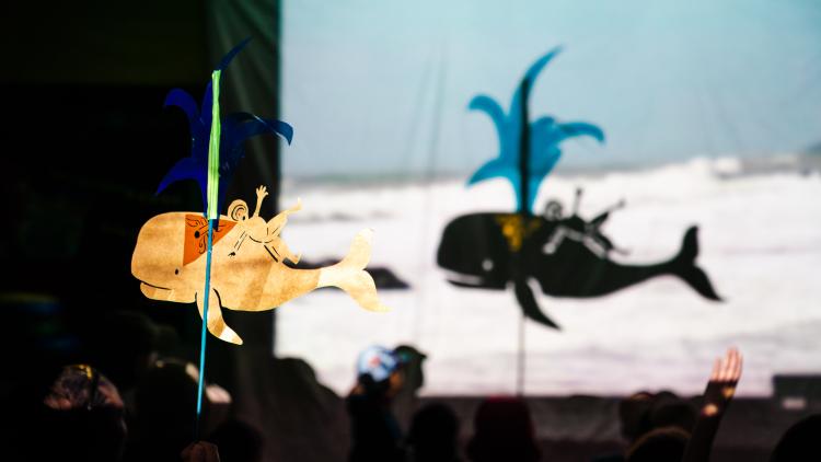Shadow puppet of a man on a whale