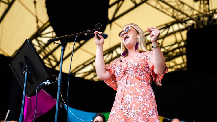 Singer in a patterned dress holding a microphone