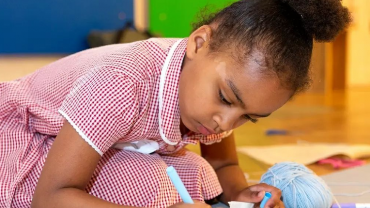 Crafts Council: A child focuses on drawing a picture as part of a previous Craft School challenge