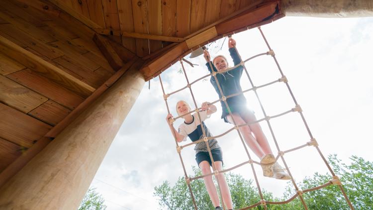 Girls climbing up rope ladder