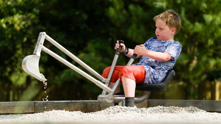 Boy using sit on gravel play digger