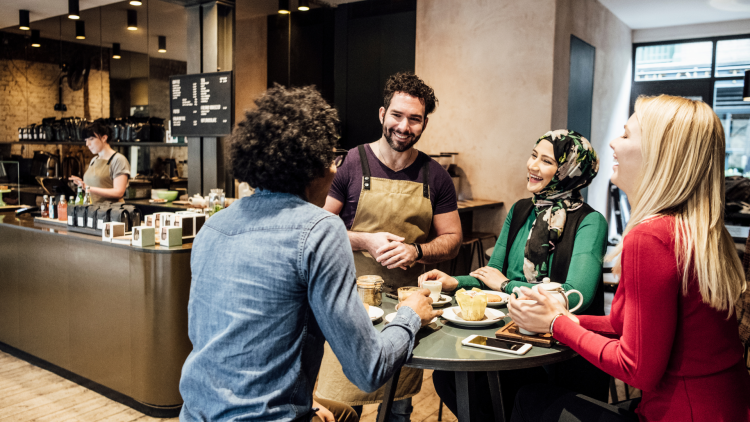 Customers in a coffee shop talking to the waiter