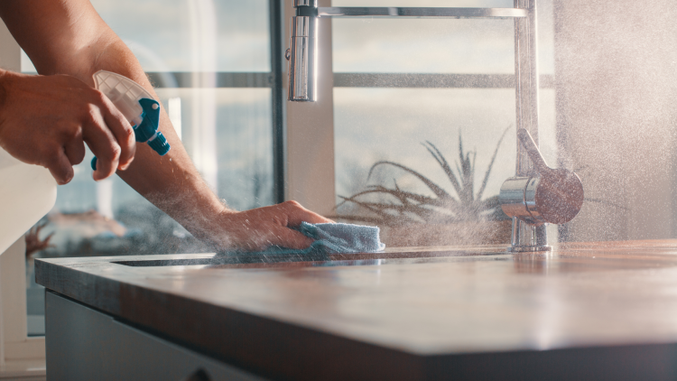 Cleaning cleaner being sprayed on kitchen worktop