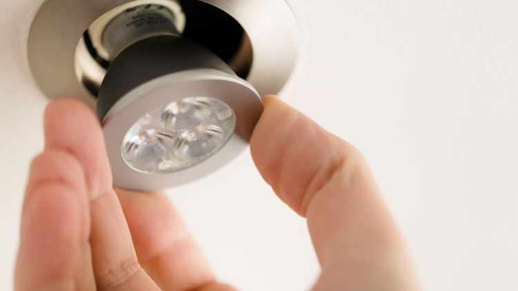 Close up of hand installing an LED bulb