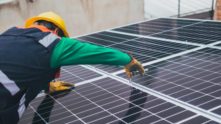 Engineer in hard hat fitting solar panels