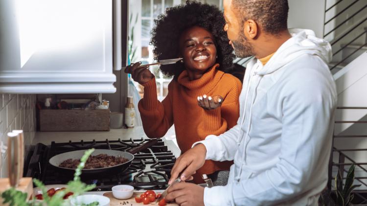 Happy couple cooking food together in a kitchen