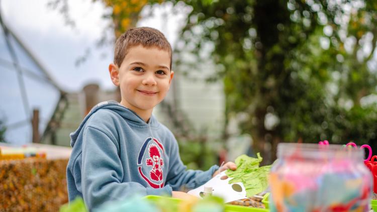 Boy in blue jumper doing crafts in Med Biome