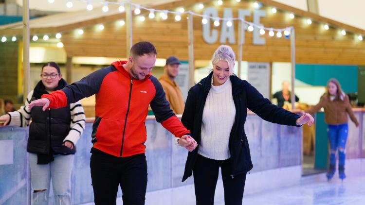 Couple holding hands ice skating