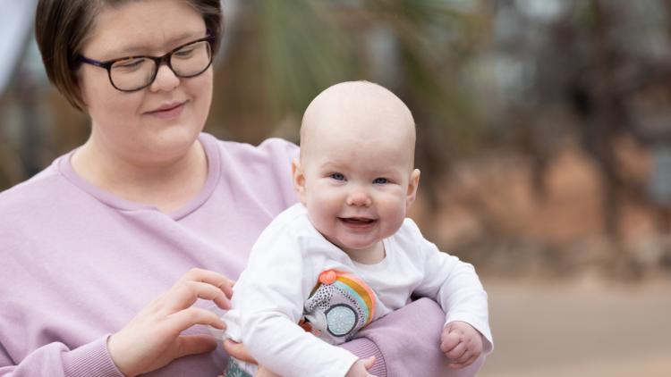 Mum holding smiling baby