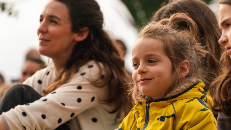 Mother and child sitting watching a show with engaged expressions