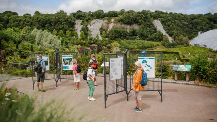 Visitors looking at photography exhibition in the Outdoor Gardens of the Eden Project