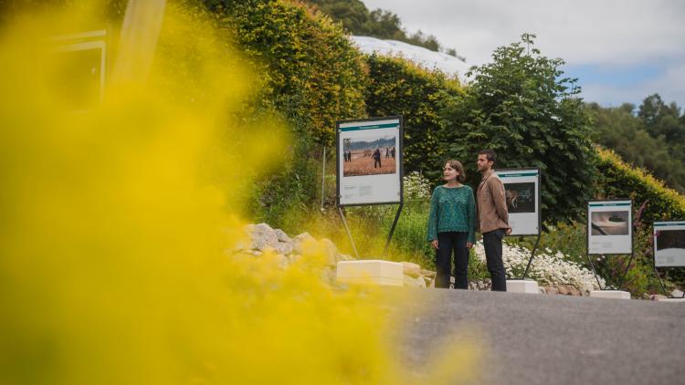 Couple looking at photography exhibition in the Outdoor Gardens of the Eden Project