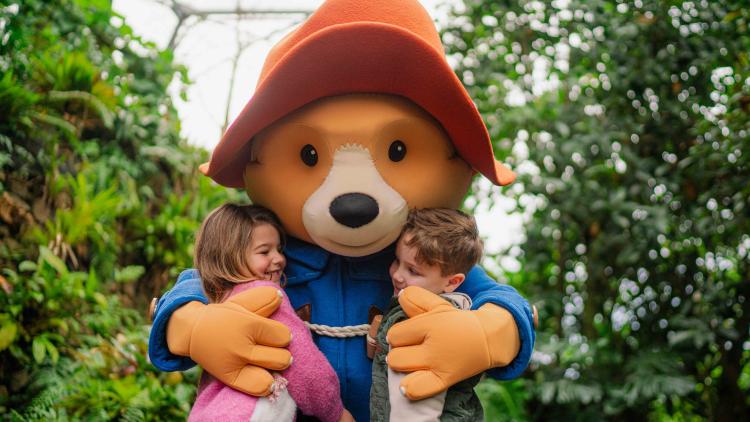 Paddington hugging two children