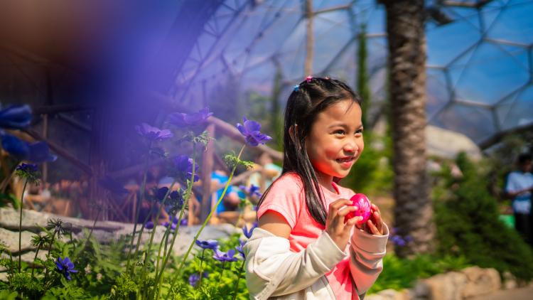 Girl holding a wooden painted Easter egg