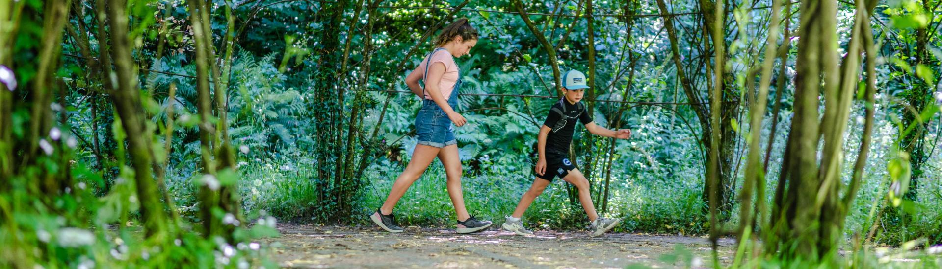 Children walking the route of a labyrinth inside a willow chamber