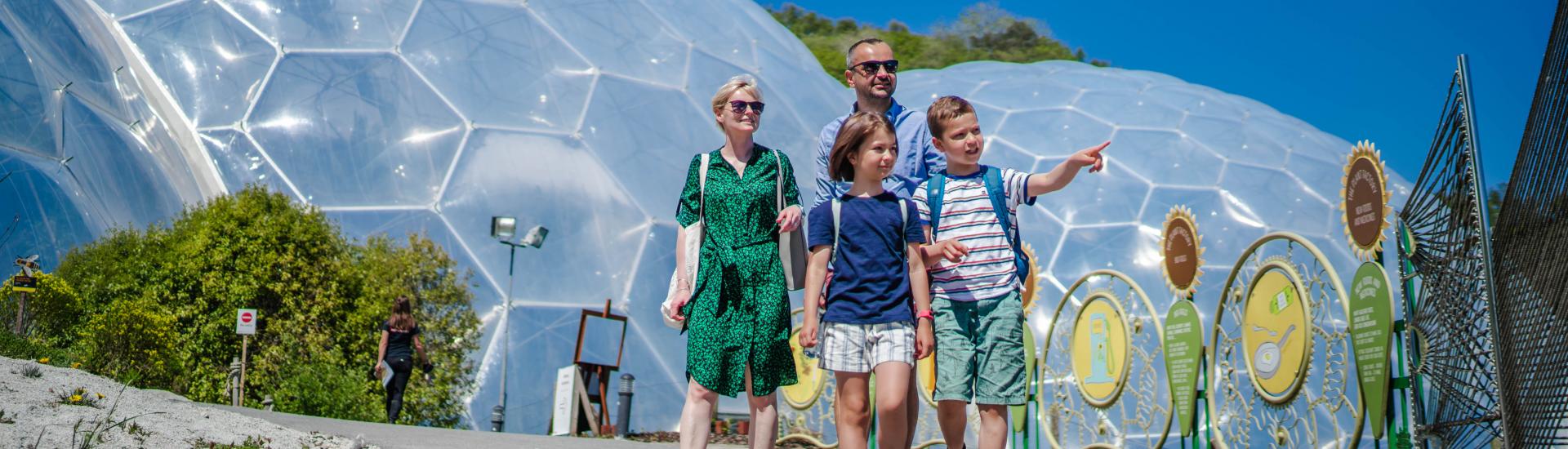 Family walking towards the camera away from the Eden Project Biomes