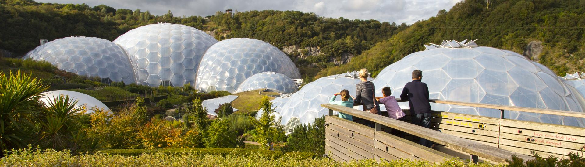 A young family looking out over the Eden biomes and gardens