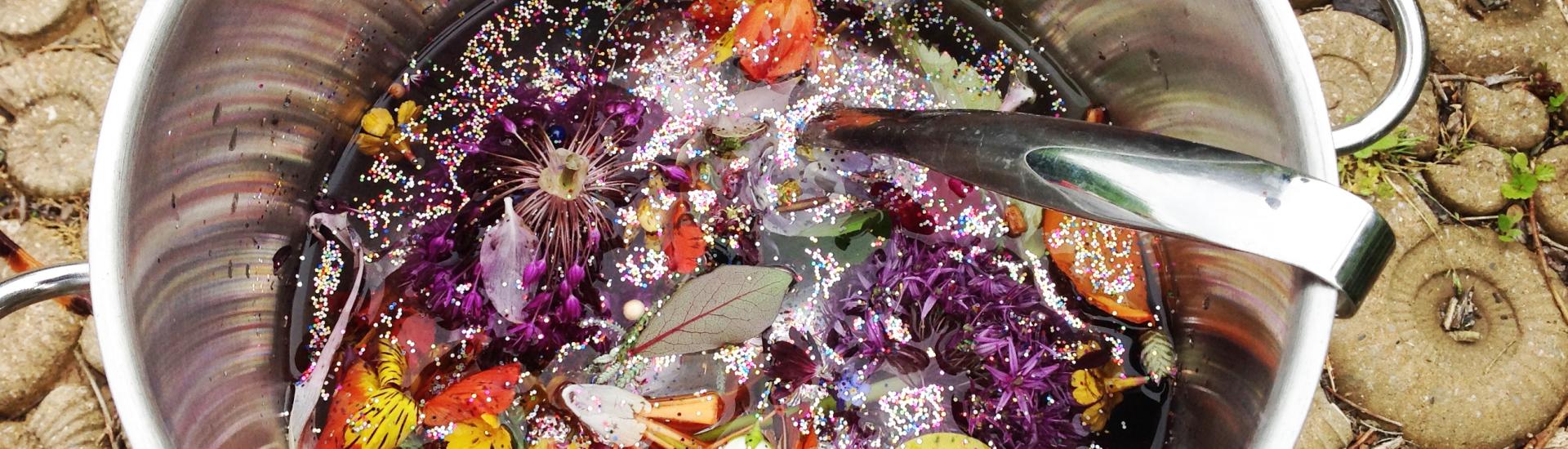 A close up of a big cauldron that has been used to mix a positive potion with fresh ingredients from nature